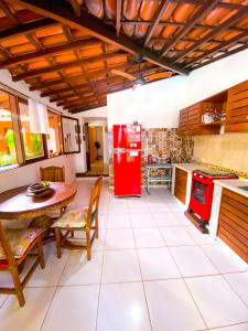 阿拉亚尔达茹达Ôxe Uai Hostel的厨房配有桌子和红色冰箱