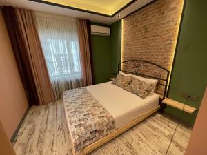 安卡拉ANKA RESİDENCE的一间卧室设有一张床和砖墙