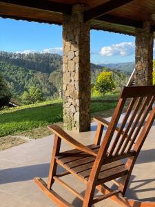 蒙特韦尔迪Pousada das Pedras的门廊上的木椅,享有美景