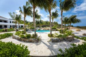 威廉斯塔德The Reef - Blue Bay Golf & Beach Resort的一个带游泳池和棕榈树的度假村