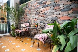 瓜伊马延Bienvenido a Café y Vino的一个带桌椅和石墙的庭院