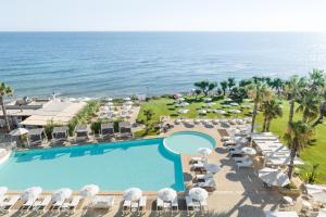 托雷坎内Canne Bianche Lifestyle Hotel的享有带游泳池和海洋的度假村的空中景致