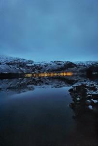 ArdluiBonnie Banks Lodge Ardlui的雪中灯光下的湖景之夜