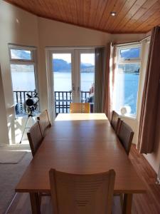 ArdluiBonnie Banks Lodge Ardlui的餐桌和椅子,享有海景