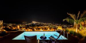 皮尔戈斯Apikia Santorini的享有游泳池的夜间景致