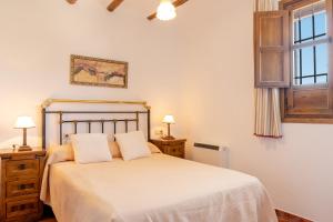 普里埃格·德·科尔多巴Cortijo La Presa的卧室配有白色床、两盏灯和一扇窗户。