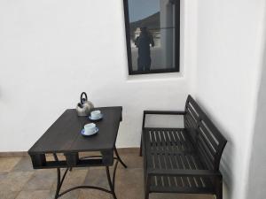MáguezFinca La Tabaiba Apartamento alto的一张黑桌、一张长凳和一张桌子及椅子