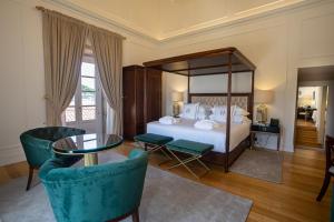 阿尔库什迪瓦尔德维什Solar do Requeijo by Luna Hotels & Resorts的卧室配有一张床和一张桌子及椅子