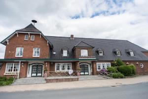 BasthorstLandhaus Hamester - Hotel & Restaurant - neu eröffnet September 2022的黑色屋顶的大型红砖房屋