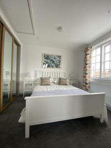 谢林汉姆The Crows Nest - Sheringham的白色卧室配有一张带枕头的大白色床