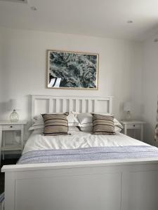 谢林汉姆The Crows Nest - Sheringham的白色卧室配有一张带枕头的大白色床