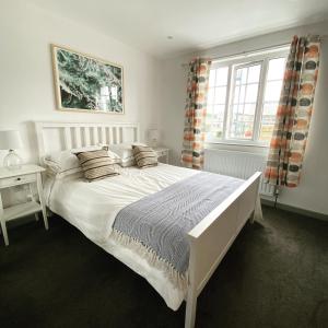 谢林汉姆The Crows Nest - Sheringham的卧室配有白色的床和窗户。