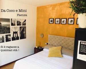 法恩莎Da Coco e Mini,l'angolo per ceramiste in viaggio -的卧室配有一张床,墙上挂有图片