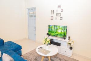 尼耶利The Stay Comfort的客厅配有蓝色的沙发和电视