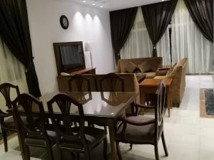 杜拉特阿拉尔Durrah Beach Apartment的客厅配有桌椅和沙发