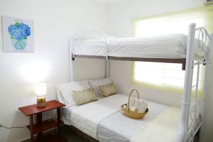 普拉亚斯Ecusuites Playas House III Resort Altamar 45Min GYE的一间卧室配有一张双层床,上面有篮子