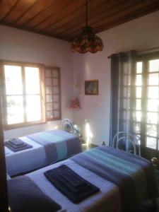 伊兹拉Panoramic Views Home in Hydra, Greece的带2扇窗户的客房内的2张床