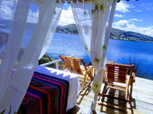 普诺Titicaca wasy lodge的水景甲板上的桌椅