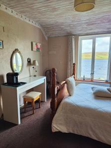 克利夫登水滨休憩食宿酒店的一间卧室配有一张床、一张书桌和一个窗户。