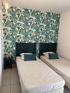 拉卡诺奥肯Villa du Golf Eden Parc的配有两张床铺的蓝色和白色壁纸客房