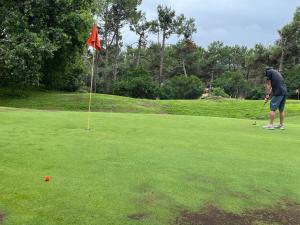 拉卡诺奥肯Villa du Golf Eden Parc的一个人在高尔夫球场打高尔夫