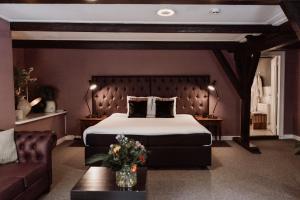 SchiphorstChâteauhotel De Havixhorst的一间卧室配有一张大床和一张沙发