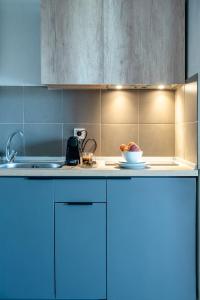 尼亚伊拉克利亚Heraclea Luxury Suites的厨房配有蓝色橱柜和一碗水果