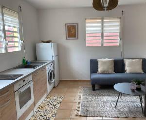 圣弗朗索瓦Appartement cosy & calme en Rez de villa的厨房以及带沙发和桌子的客厅。