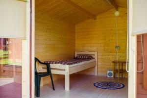 Tiidu基维马度假屋的木制客房的一张床位,配有椅子