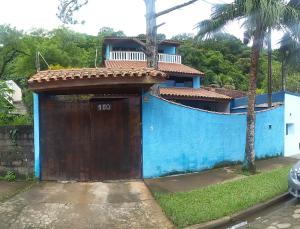 卡拉瓜塔图巴Casa Azul的蓝色房子,带有棕色的门,设有阳台