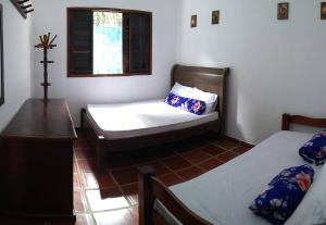 卡拉瓜塔图巴Casa Azul的小房间设有两张床和窗户
