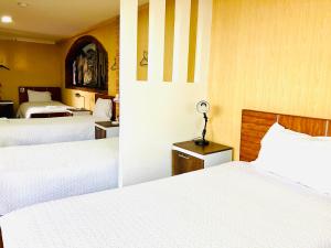 基多Quito Terrace的酒店客房,配有两张带白色床单的床