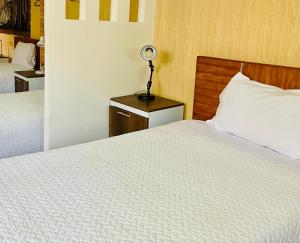 基多Quito Terrace的一间卧室设有两张床和一张桌子上的台灯。