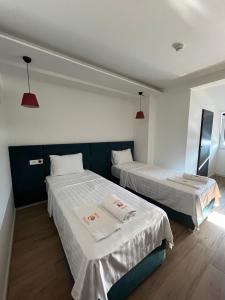斯特鲁加Kubi Hotel的一间设有两张带白色床单和红灯的床的房间