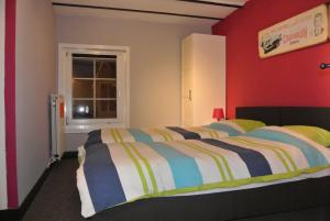 弗朗科尔尚拉多彦度假屋的一间卧室设有一张床和红色的墙壁