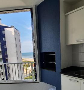 马蒂尼奥斯Apto Resort Cambuhy frente Mar até 6 pessoas的阳台享有海景的厨房