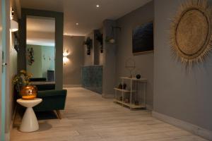 圣胡安Trópica Beach Hotel的走廊设有绿色沙发和镜子