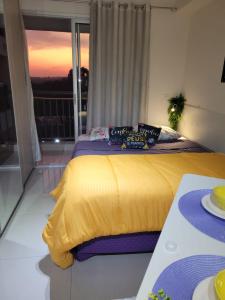 圣保罗Lindo loft apartamento studio em Santana, perto do Expo Center Norte, Anhembi, Sambodromo, Campo de Marte, Zona Norte的一间卧室设有一张黄色的床和一个阳台