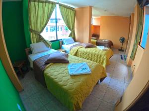 普约Hostal Puyo的酒店客房设有两张床和窗户。