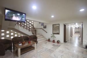 斯勒尼克Teju Hotels的一间带电视和楼梯的客厅