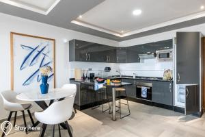 阿加迪尔Stayhere Agadir - Ocean View Residence的厨房配有黑色橱柜和桌椅