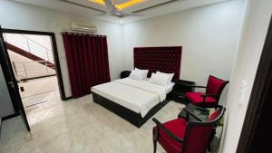 伊斯兰堡Hotel 11的一间卧室配有一张床和一张红色椅子