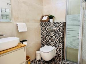 纳哈里亚הפינה של טלי בנהריה - אירוח וספא בריאות מחומם的浴室配有卫生间、盥洗盆和淋浴。