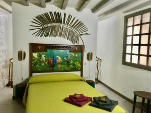 Cadalso de los VidriosLa Casona del Tío Pedro的卧室配有一张黄色的床,墙上挂着一幅画