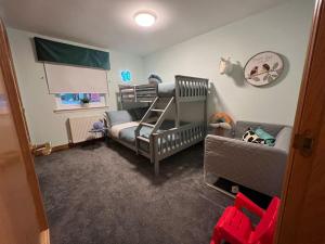 阿罗柴尔WATERSIDE 3 BED COTTAGE, HOT TUB, SAUNA, PVT BEACH的儿童间 - 带双层床和婴儿床