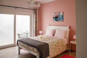 辛特拉Flor&Fidalgo Guest House的一间卧室配有一张床和粉红色的墙壁