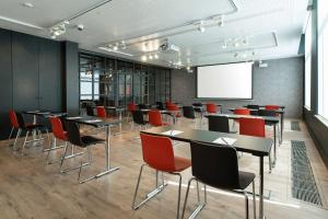 布鲁塞尔Radisson RED Brussels的一间会议室,配有桌椅和白板