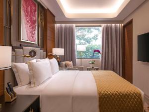 马尼拉Admiral Hotel Manila - MGallery的一间设有大床和窗户的酒店客房