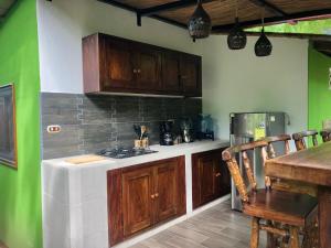 La LagunaCasa Única - Room with breakfast or Cabins with kitchen的厨房配有木制橱柜、桌子和炉灶。
