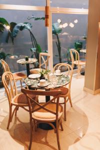 圣米格尔·德·图库玛LG Golden Suites的桌子和椅子,上面有盘子和杯子